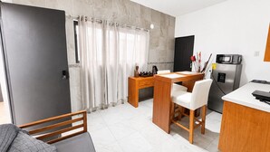 A compact living space with a kitchenette, a dining area, and a separate sleeping area.
