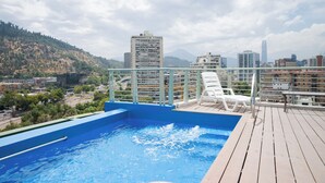 A rooftop pool with a cityscape view, including mountains and high-rise buildings. - 1BR in Heart of Providencia Urban Style (Providencia)