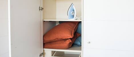 Un armario con puertas abiertas que muestra estantes y espacio para colgar.