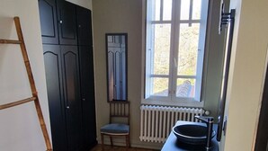 Una cocina con suelo de madera, una ventana y un radiador.
