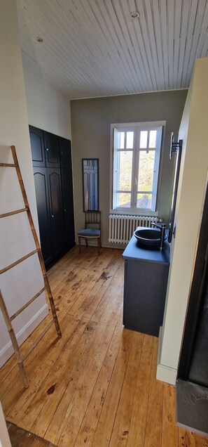 Una cocina con suelo de madera, una ventana y un radiador.