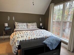 A bedroom with a bed, bedside tables, a bench, and a window with a view of trees. - Hilltop Home w/Mtn View,firepit & wifi.Close to DT (Franklin)