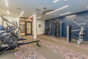 A gym with treadmills, weight machines, and a ceiling fan. - 5 min from NRG - Pool, Gym & Free Parking (Houston)