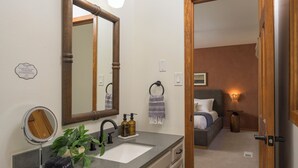 A bathroom with a sink, mirror, and a towel rack. - 3-bdrm home in Evergreen w/sweeping mountain views, hot tub, sauna, & fire place (Evergreen)