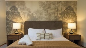 A hotel room with a large bed, two bedside lamps, and a textured wall mural. - 3-bdrm home in Evergreen w/sweeping mountain views, hot tub, sauna, & fire place (Evergreen)