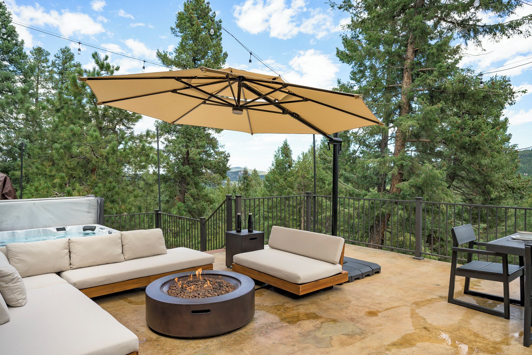 An outdoor patio with a sofa, a round table, and a fire pit.