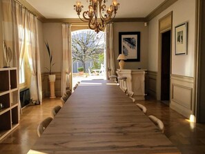 A long dining table with chairs, a chandelier, a fireplace, and framed artwork on the walls. - 5-star villa with a large pool, hot tub, and sauna in the Loire Valley (Montrichard Val de Cher)