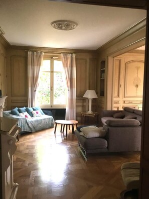 A room with a sofa, a chair, a small table, and a lamp. - 5-star villa with a large pool, hot tub, and sauna in the Loire Valley (Montrichard Val de Cher)