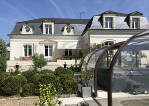 A large, two-story house with a covered patio, a conservatory, and a garden. - 5-star villa with a large pool, hot tub, and sauna in the Loire Valley (Montrichard Val de Cher)