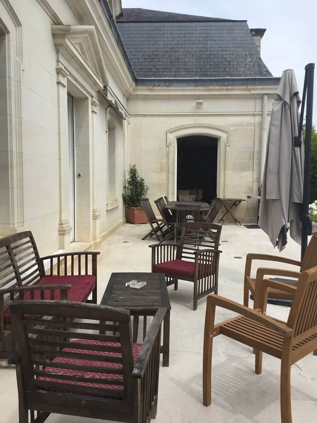 An outdoor patio area with wooden furniture, a table, and a fire pit.