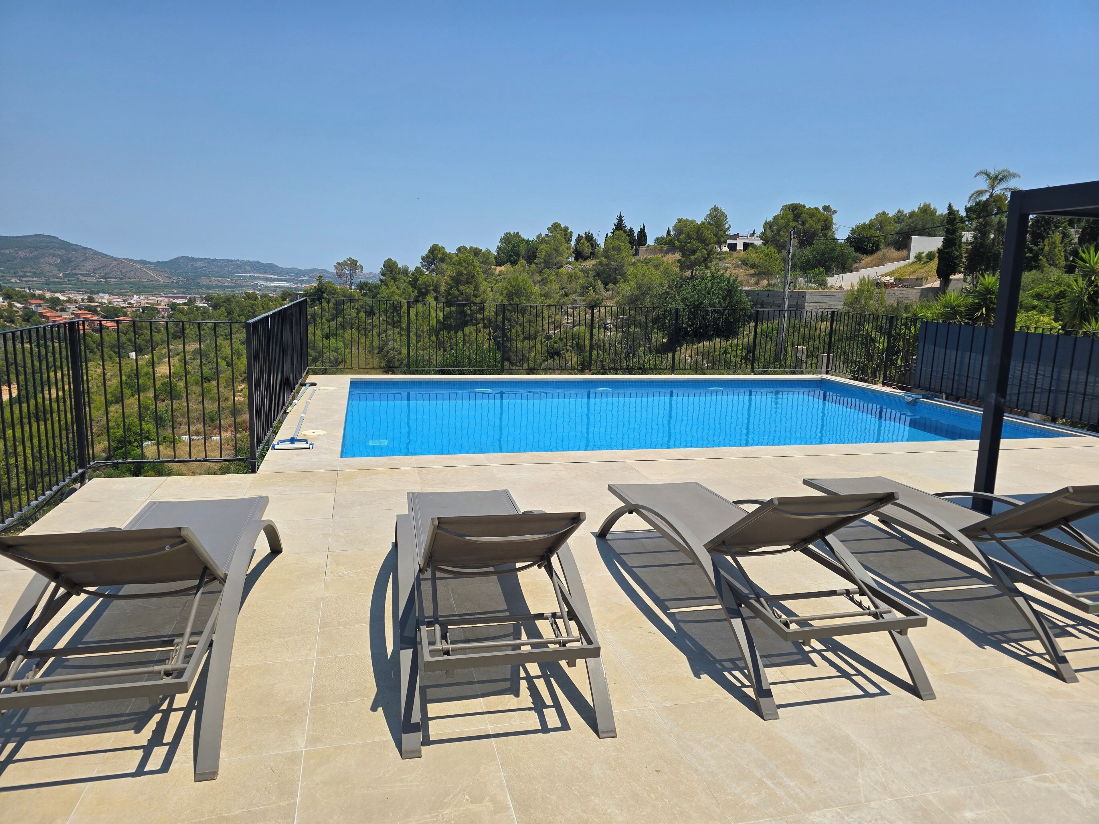 A swimming pool with lounge chairs and a view of the landscape.