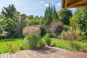 A wooden deck with a potted plant and a bird feeder.