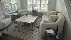 A living room with a sofa, armchair, coffee table, and a rug. - Beautiful designer home located near SouthEnd, LoSo, Rail and Uptown (Charlotte)