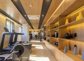 Ein Fitnessstudio mit Laufbändern, Gymbällen und Gewichten.