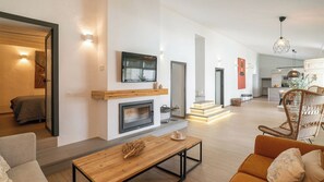 A modern living room with a fireplace, a dining area, and a kitchen in the background. - Peña de los Enamorados Antequera by Ruralidays (Málaga)