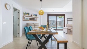 A modern dining area with a wooden table, teal chairs, and a bench. - Oasis de Cáñar by Ruralidays (Granada)