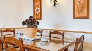 A dining table with chairs, a potted plant, and a wall-mounted light fixture. - Casa Viladán Colmenar by Ruralidays (Málaga)