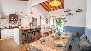 A modern kitchen with a central island, bar stools, and pendant lighting. - La Casilla del Mirador del Torcal Villanueva de la Concepción by Ruralidays (Province of Málaga)