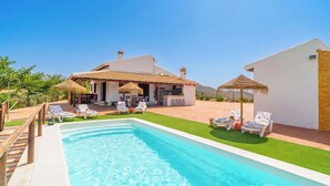 A swimming pool with lounge chairs, a bar area, and a house with a tiled roof. - La Casilla del Mirador del Torcal Villanueva de la Concepción by Ruralidays (Province of Málaga)