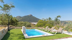 A swimming pool with a view of mountains, surrounded by grass and lounge chairs. - Alma de Olivo El Gastor by Ruralidays (Cádiz)