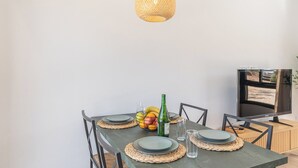 A dining table set with plates, a bottle, and a fruit bowl. - Alma de Olivo El Gastor by Ruralidays (Cádiz)