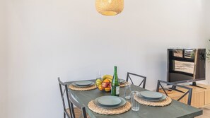 A dining table set with plates, a bottle, and a fruit bowl. - Alma de Olivo El Gastor by Ruralidays (Cádiz)