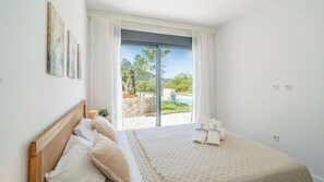 A bedroom with a bed, a window with curtains, and a view of a pool and greenery. - Alma de Olivo El Gastor by Ruralidays (Cádiz)