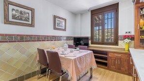 A dining area with a table set for two, a television, and a window with a view.