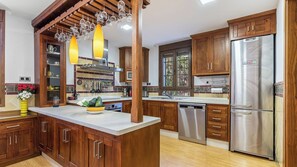 Une cuisine moderne avec des meubles en bois, des appareils en acier inoxydable et un îlot central.