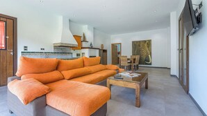 A modern living room with a sofa, coffee table, and dining area. - Casa Rural El Mayorazgo Saleres by Ruralidays (Granada)