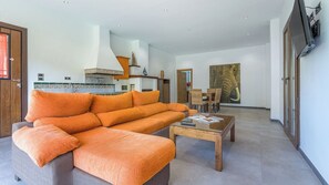A modern living room with a sofa, coffee table, and dining area. - Casa Rural El Mayorazgo Saleres by Ruralidays (Granada)