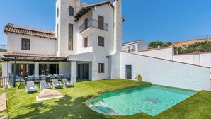 A two-story house with a swimming pool, a covered patio with outdoor furniture, and a white exterior. - Casa Rural El Mayorazgo Saleres by Ruralidays (Granada)