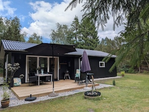 A cabin with a deck, outdoor seating, a grill, and a small garden. - Holiday home in Lyngshuse. In Kølkær near Herning (Herning)
