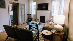 A living room with a fireplace, a television, and a sofa.