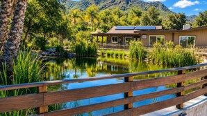 A house with a pond, surrounded by greenery and mountains. -     Peaceful 1BR Cabin Near Malibu • AC • Pet Friendly (Agoura Hills)