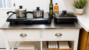 A kitchen with stainless steel appliances, a potted plant, and a bottle of olive oil. -     Peaceful 1BR Cabin Near Malibu • AC • Pet Friendly (Agoura Hills)