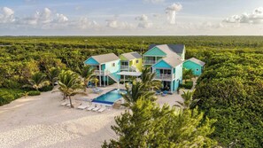 A beachfront property with multiple houses, a swimming pool, and a sandy beach. - The Cottages Collection - 10 Oceanfront Suites and 2 BR Penthouse (East End)