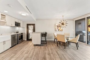 Eine moderne Küche mit weißen Schränken, Edelstahlgeräten und Holzboden.