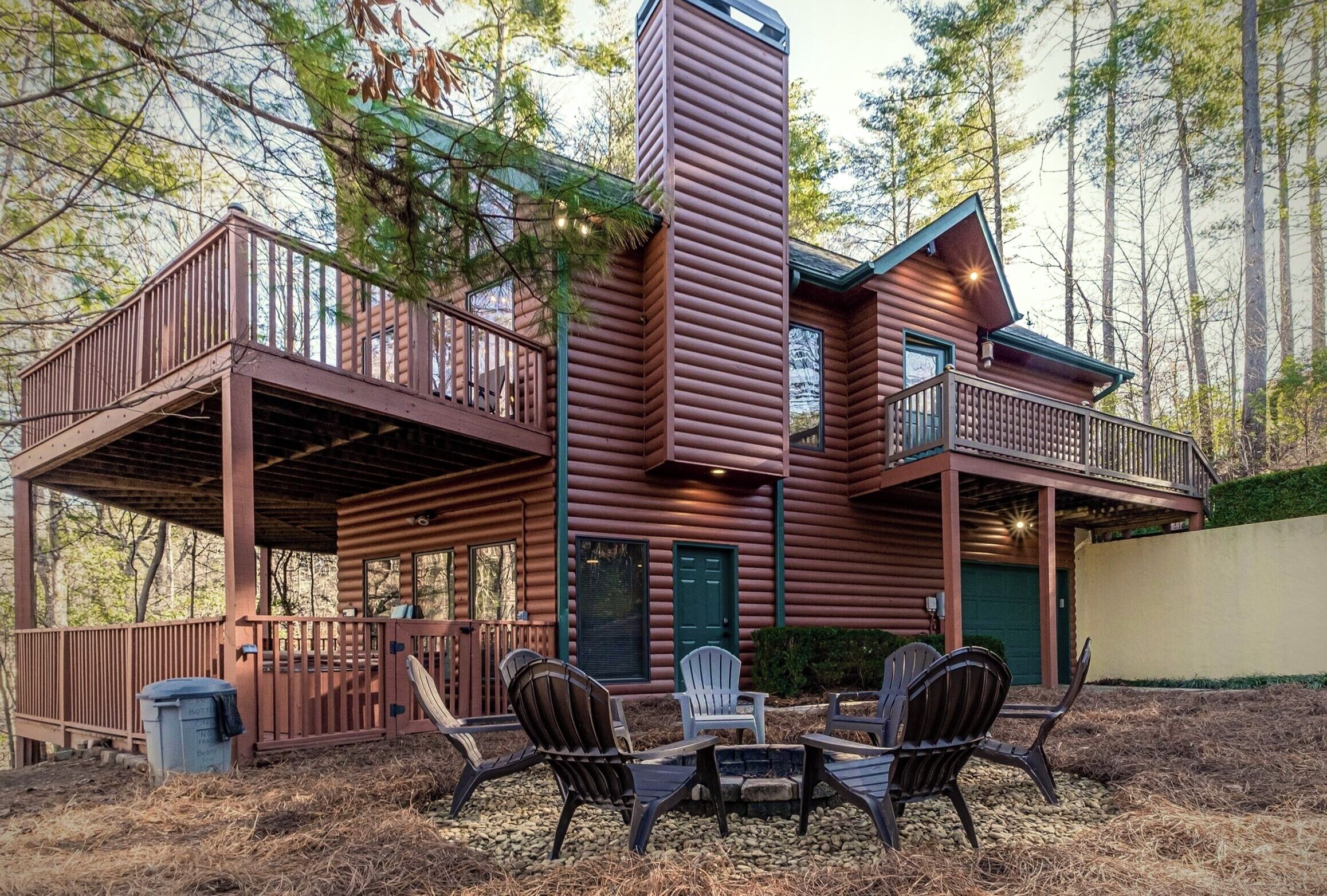 A cabin with a deck, outdoor seating, and a chimney.
