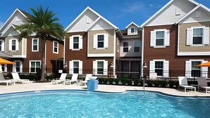 A pool area with lounge chairs and a clear blue pool. - Gated Resort Home, Pool & Hot Tub Near Disney (Kissimmee)