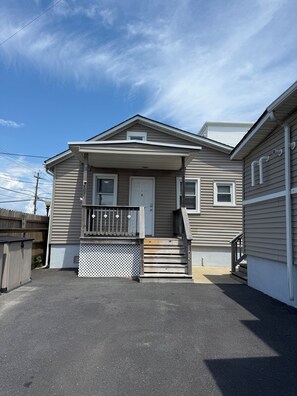 A single-story house with a front porch, a small set of stairs, and a wooden fence. - A Slice of Seaside Charm — Comfortable 2-Bedroom Cottage - 2 blocks to beach (Seaside Heights)