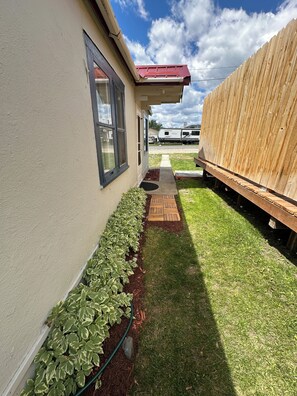 A residential property with a paved pathway, a wooden deck, and a fenced yard. - Quaint 1-bedroom house in charming Deer Lodge perfect for a getaway. (Deer Lodge)