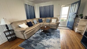 Una sala de estar con un sofá modular, una mesa de centro, una lámpara y un tapete azul con estampado.