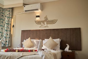 Ein Hotelzimmer mit Bett, Kissen, einer Klimaanlage und einer Wanddekoration.