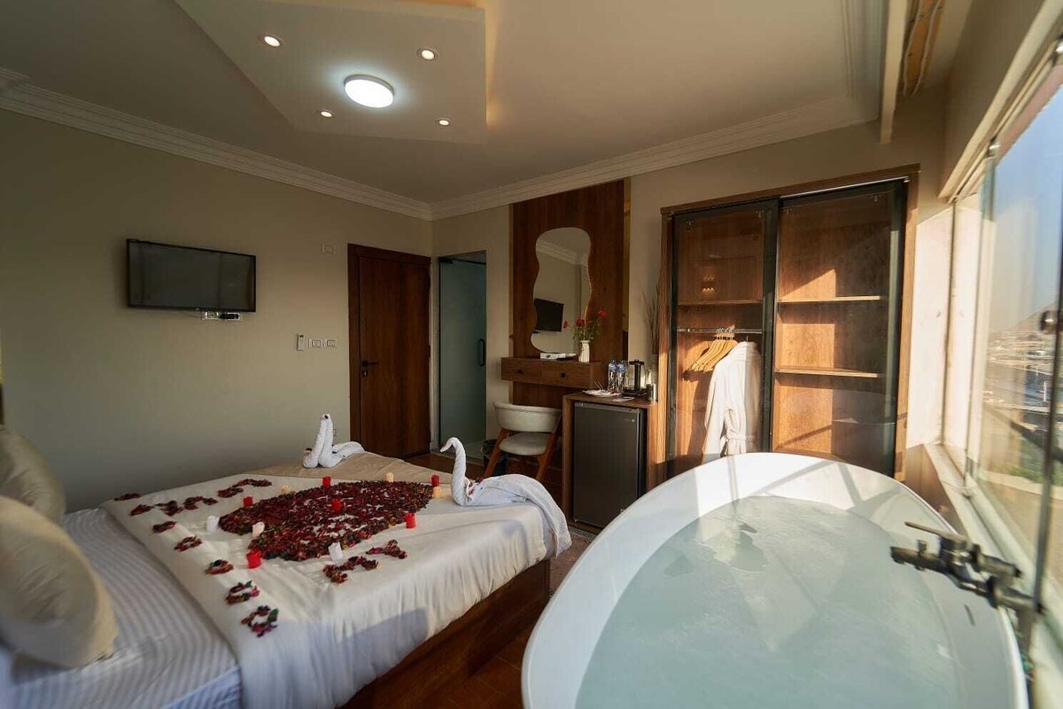 Ein Schlafzimmer mit einem Bett, einer Badewanne, einem Fernseher und einem Kleiderschrank.