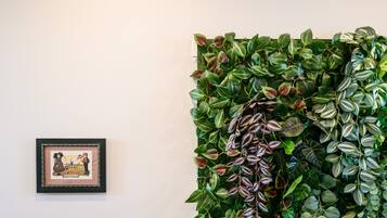 A wall with a framed picture and a vertical garden.