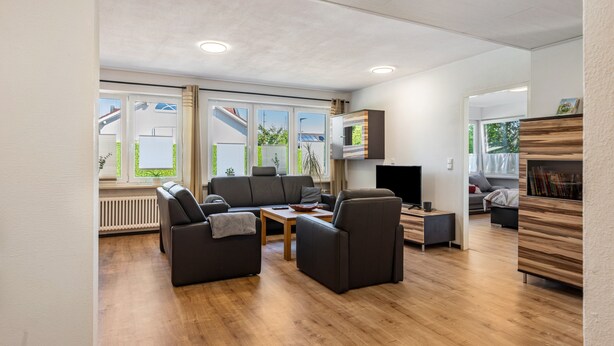 A modern living room with a sofa set, a coffee table, and a TV.