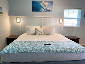 A neatly made bed with a blue and white patterned bedspread, two white pillows, and a remote control on the bed. - HILLSIDE TWO BEDROOM VILLA - OCEANVIEW (Georgetown)