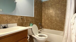 A bathroom with a toilet, sink, vanity, and bathtub. - HILLSIDE TWO BEDROOM VILLA - OCEANVIEW (Georgetown)
