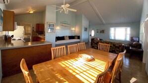 A spacious living area with a dining table, chairs, a sofa, and a ceiling fan. - HILLSIDE TWO BEDROOM VILLA - OCEANVIEW (Georgetown)